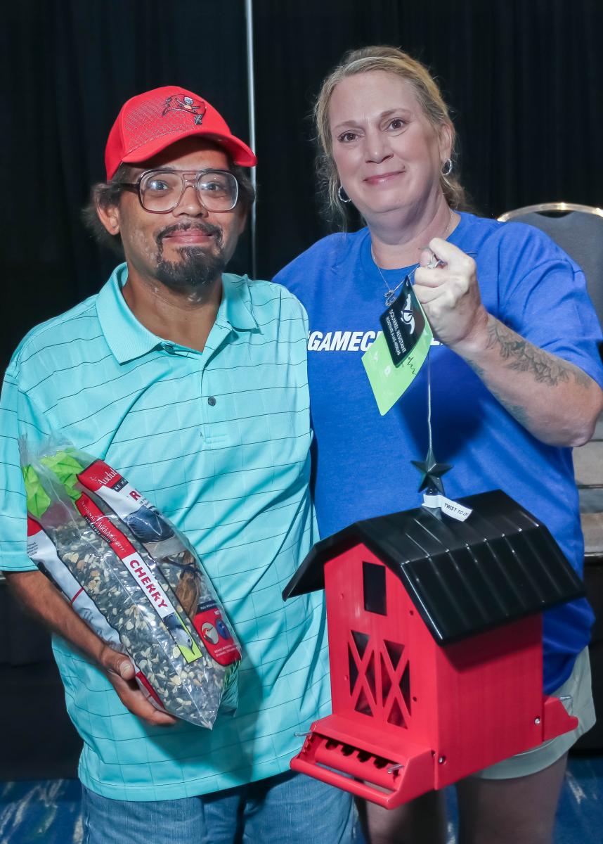 Pictured: Melissa Scott from Port Charlotte Lowes presents Trevor with a bird house and bird food to put in his new backyard.