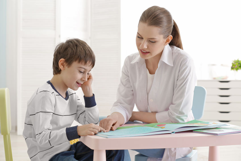 adult volunteer reading with young boy