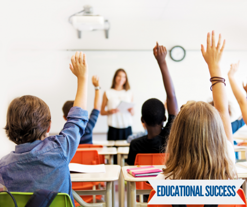 elementary school students with their hands raised