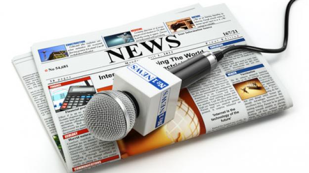 generic newspaper with news microphone sitting on top of it
